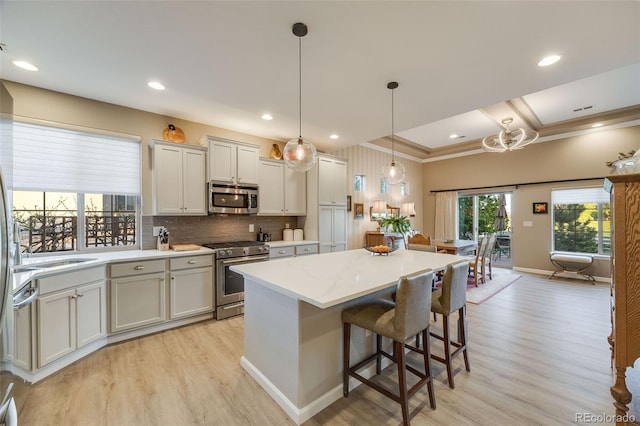 19688 E 52nd Ave, Denver, CO 80249 - kitchen with appliances with stainless steel finishes, light wood finished floors, a kitchen island, tasteful backsplash, and recessed lighting
