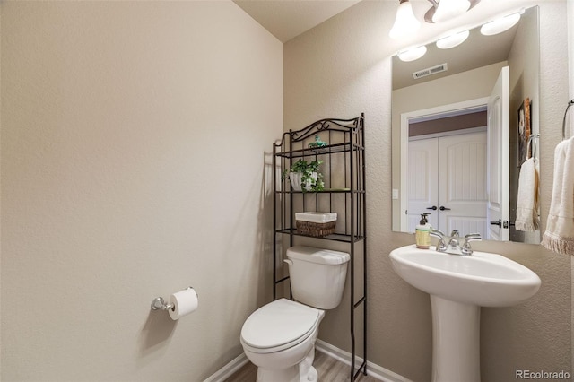 19688 E 52nd Ave, Denver, CO 80249 - bathroom with toilet, wood finished floors, and baseboards