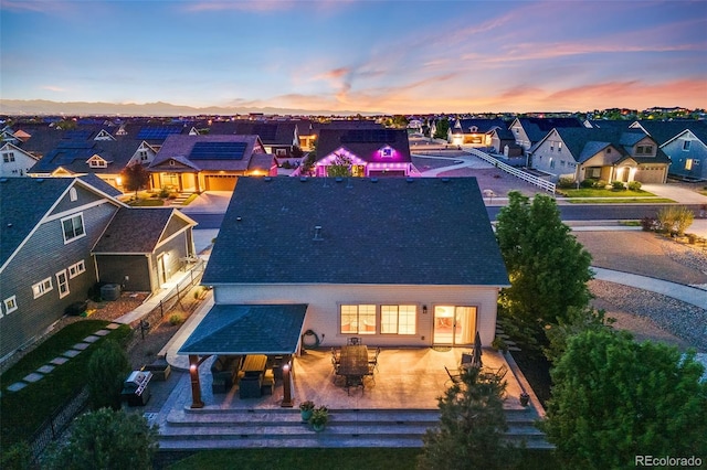 19688 E 52nd Ave, Denver, CO 80249 - back of house at dusk featuring a residential view and roof with shingles