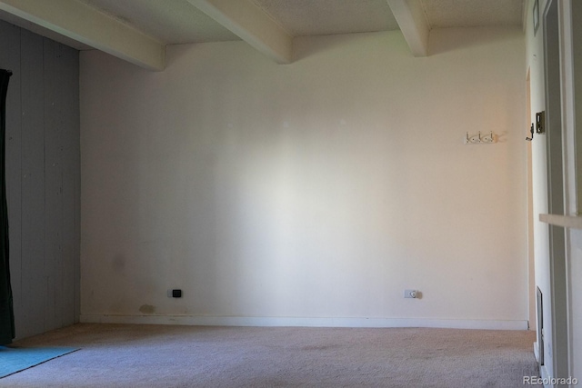 carpeted spare room with beamed ceiling