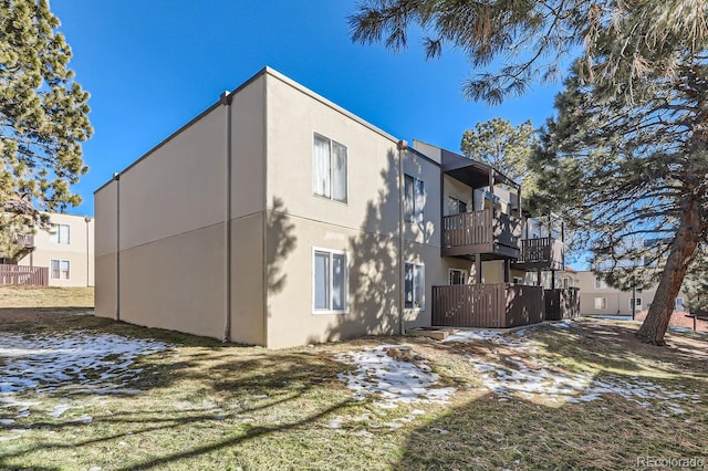 rear view of house with a balcony and a lawn