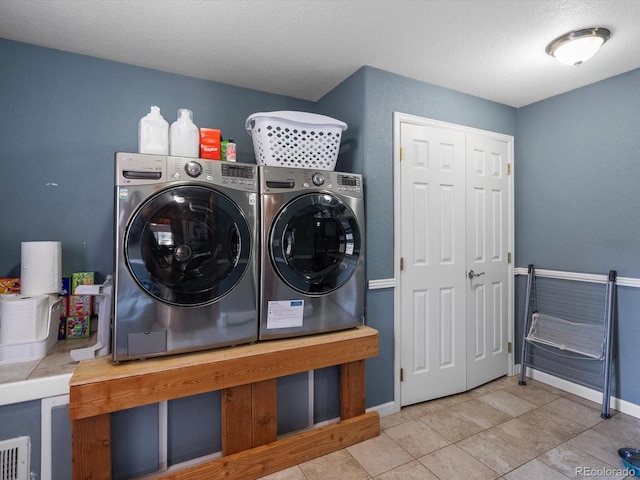 2571 SW Grapevine Rd, Idledale, CO 80453 - laundry area featuring washer and dryer, tile patterned flooring, baseboards, and a textured ceiling