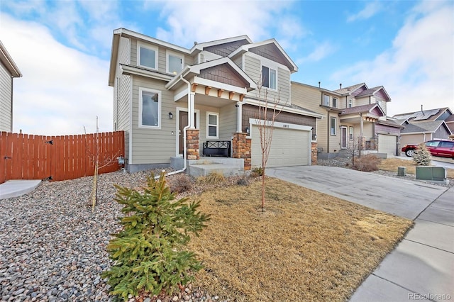 craftsman-style house with a garage, concrete driveway, stone siding, and fence