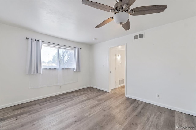 empty room with ceiling fan and light hardwood / wood-style flooring