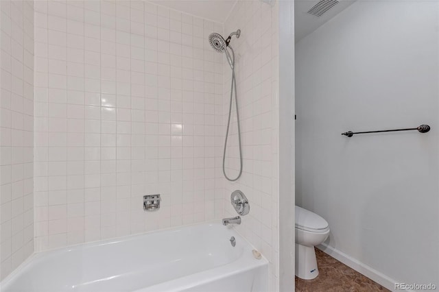 bathroom with tile patterned floors, tiled shower / bath combo, and toilet