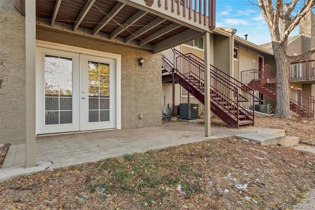 property entrance featuring french doors, cooling unit, and a patio