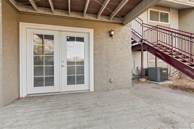 doorway to property featuring french doors, a patio, and cooling unit