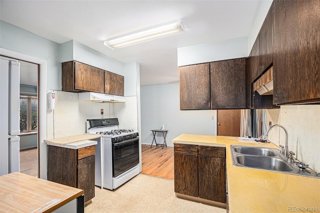 9590 Lowell Blvd, Westminster, CO 80031 - kitchen with range with gas stovetop, dark brown cabinets, and under cabinet range hood