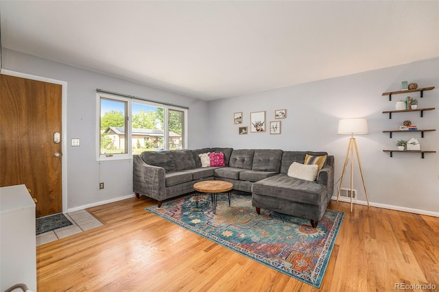 living room featuring baseboards, visible vents, and wood finished floors