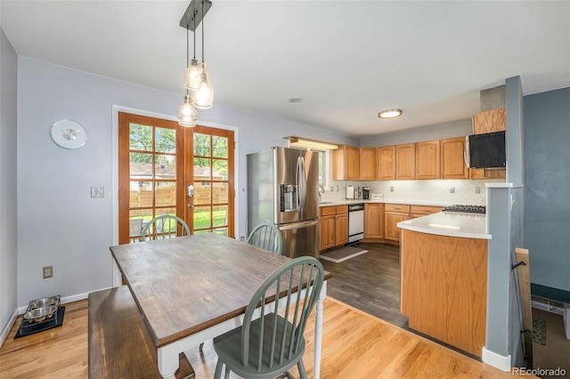 kitchen featuring french doors, stainless steel fridge with ice dispenser, light countertops, dark wood-type flooring, and dishwashing machine