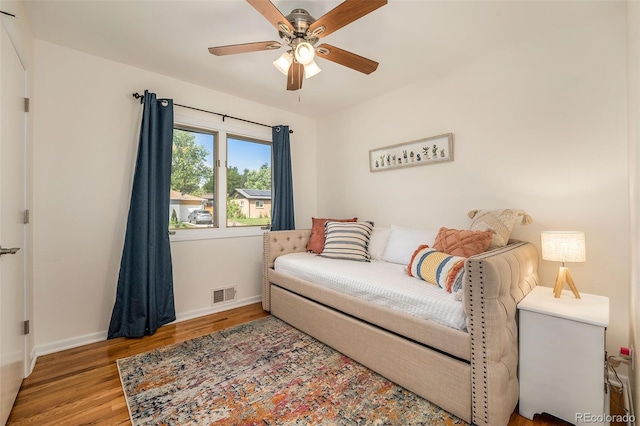 living room with visible vents, ceiling fan, baseboards, and wood finished floors