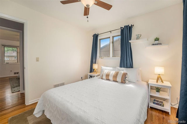 bedroom with multiple windows, wood finished floors, and visible vents