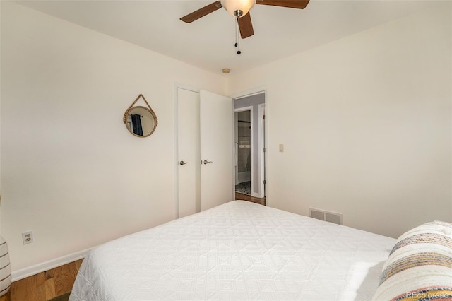 bedroom featuring baseboards, wood finished floors, visible vents, and a ceiling fan