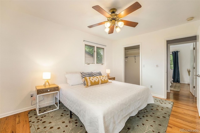 bedroom with light wood-style floors, baseboards, and a ceiling fan