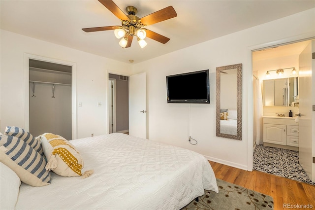 bedroom featuring a closet, ceiling fan, ensuite bath, and wood finished floors