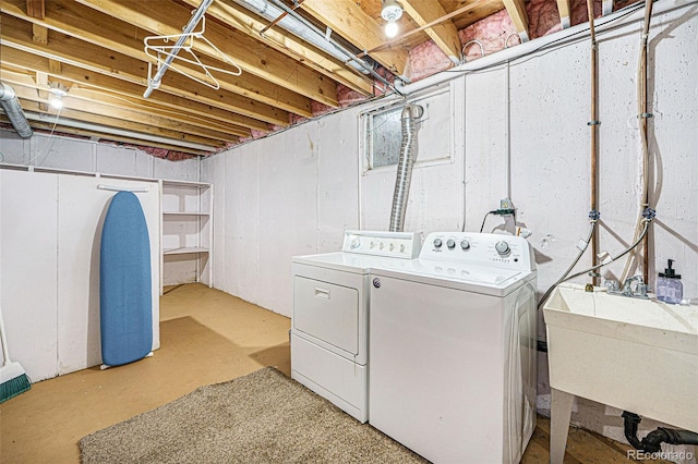 laundry area with laundry area, a sink, and washer and dryer