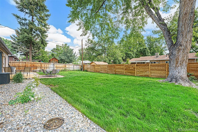 view of yard with a fenced backyard, a patio, and central AC