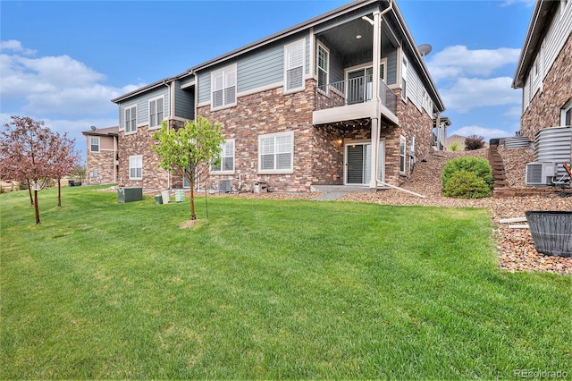 24943 E Phillips Pl, Aurora, CO 80016 - back of house with a lawn, a balcony, cooling unit, and stone siding