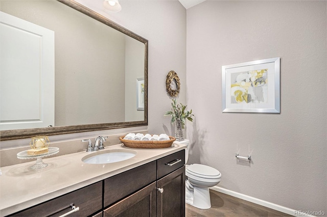 24943 E Phillips Pl, Aurora, CO 80016 - bathroom with toilet, vanity, wood finished floors, and baseboards