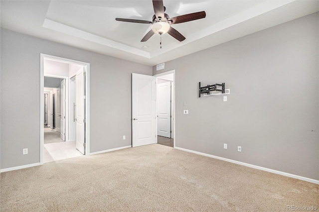 24943 E Phillips Pl, Aurora, CO 80016 - unfurnished bedroom featuring light carpet, a tray ceiling, and baseboards