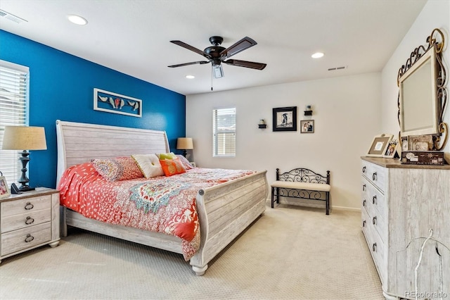 bedroom featuring multiple windows, ceiling fan, and light colored carpet