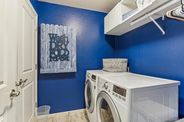 laundry room with washer and dryer and a textured ceiling