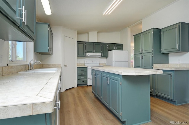 164 Robert Dr, Buena Vista, CO 81211 - kitchen featuring white appliances, exhaust hood, a sink, light countertops, and a center island