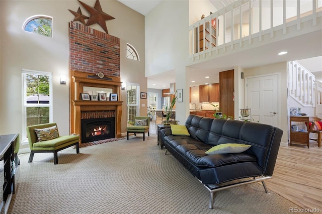 16268 E Belleview Dr, Centennial, CO 80015 - living room featuring a high ceiling, a brick fireplace, stairs, and light wood finished floors