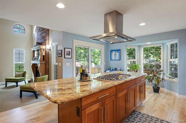 16268 E Belleview Dr, Centennial, CO 80015 - kitchen with island exhaust hood, stainless steel gas cooktop, light stone countertops, healthy amount of natural light, and recessed lighting
