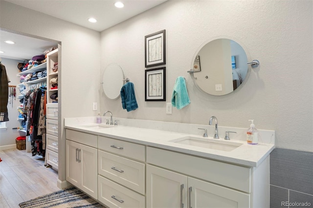 16268 E Belleview Dr, Centennial, CO 80015 - bathroom featuring double vanity, wood finished floors, recessed lighting, and a spacious closet