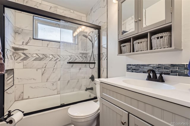 full bathroom with shower / bath combination with glass door, decorative backsplash, vanity, and toilet