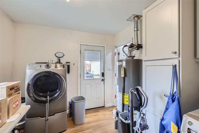 laundry room featuring water heater, cabinets, light hardwood / wood-style floors, and washer / dryer