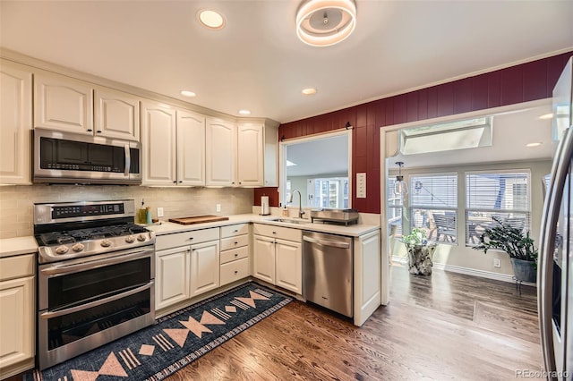 2684 S Adams St, Denver, CO 80210 - kitchen with appliances with stainless steel finishes, a sink, wood finished floors, light countertops, and plenty of natural light