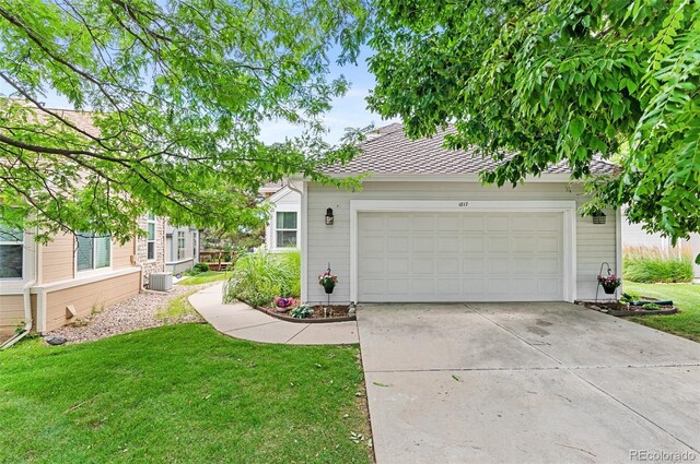 view of front of home featuring central air condition unit, a garage, and a front yard