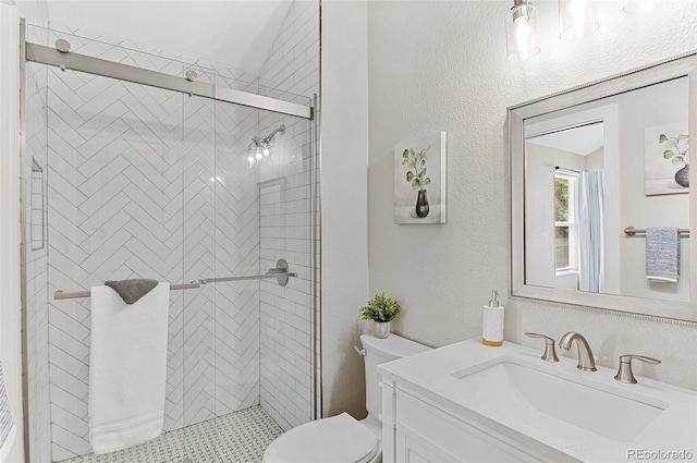 bathroom featuring toilet, vanity, and walk in shower