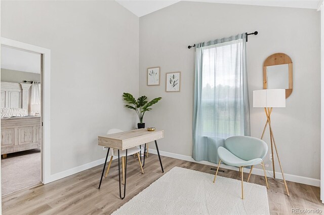 office space with light colored carpet and lofted ceiling