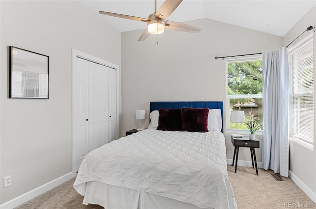 carpeted bedroom featuring ceiling fan, a closet, multiple windows, and lofted ceiling