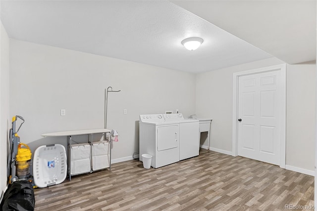 laundry room featuring washing machine and dryer, a textured ceiling, and hardwood / wood-style floors