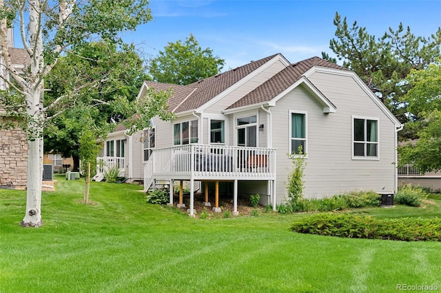 rear view of property with central AC unit, a deck, and a lawn