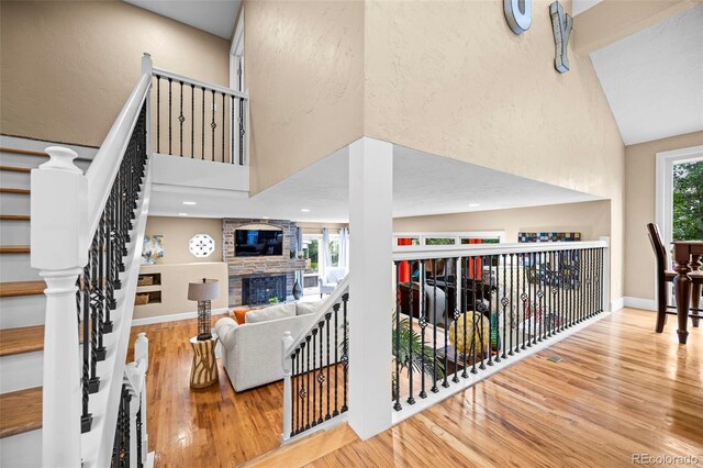 7717 S Grape Ct, Centennial, CO 80122 - living area featuring a high ceiling, wood finished floors, a fireplace, baseboards, and stairs