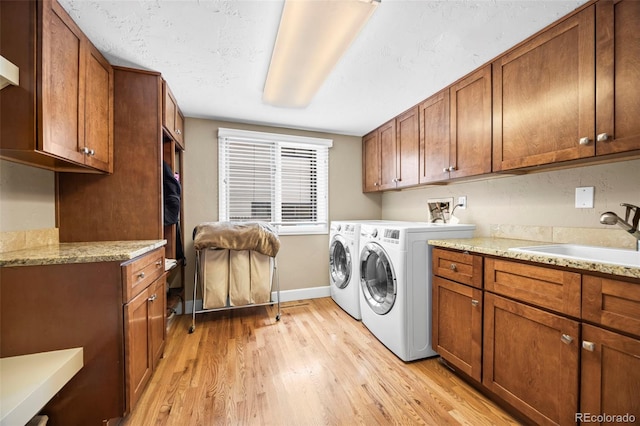 7717 S Grape Ct, Centennial, CO 80122 - laundry area featuring cabinet space, independent washer and dryer, light wood finished floors, and baseboards