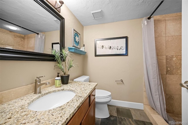 7717 S Grape Ct, Centennial, CO 80122 - bathroom featuring vanity, a tile shower, toilet, baseboards, and a textured ceiling