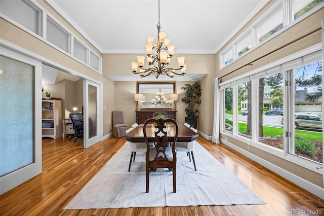 7717 S Grape Ct, Centennial, CO 80122 - dining space featuring a chandelier, baseboards, wood finished floors, a high ceiling, and ornamental molding