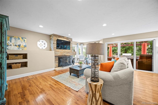 7717 S Grape Ct, Centennial, CO 80122 - living room featuring wood finished floors, a stone fireplace, recessed lighting, and baseboards