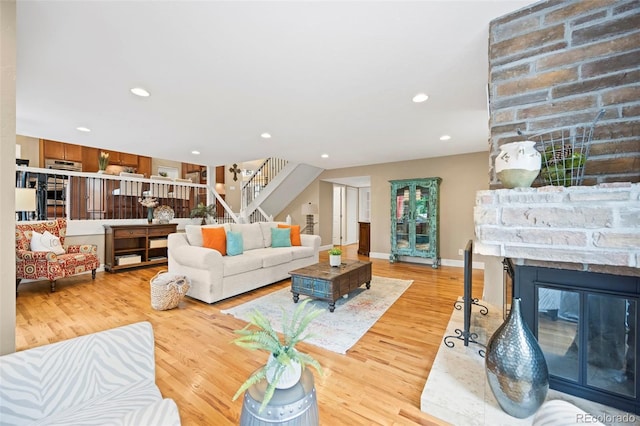 7717 S Grape Ct, Centennial, CO 80122 - living area featuring stairway, light wood-style flooring, a multi sided fireplace, recessed lighting, and baseboards