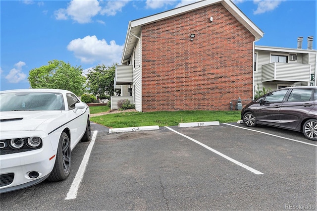 view of property exterior featuring uncovered parking and brick siding