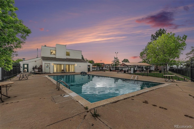 view of swimming pool featuring a patio and fence