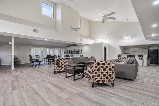 living area featuring ceiling fan, high vaulted ceiling, wood finished floors, and healthy amount of natural light