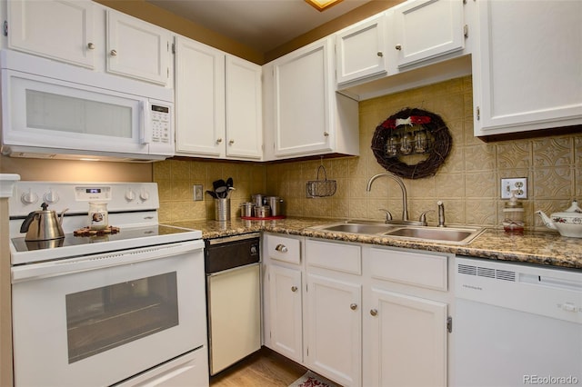 kitchen featuring white appliances, white cabinetry, a sink, and decorative backsplash