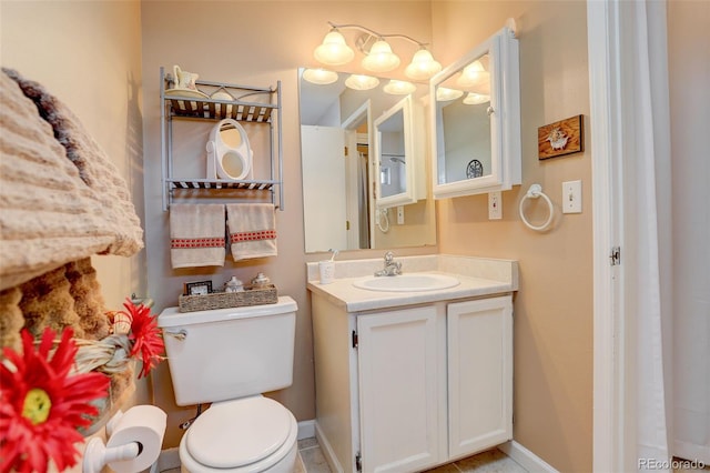bathroom with vanity, baseboards, and toilet